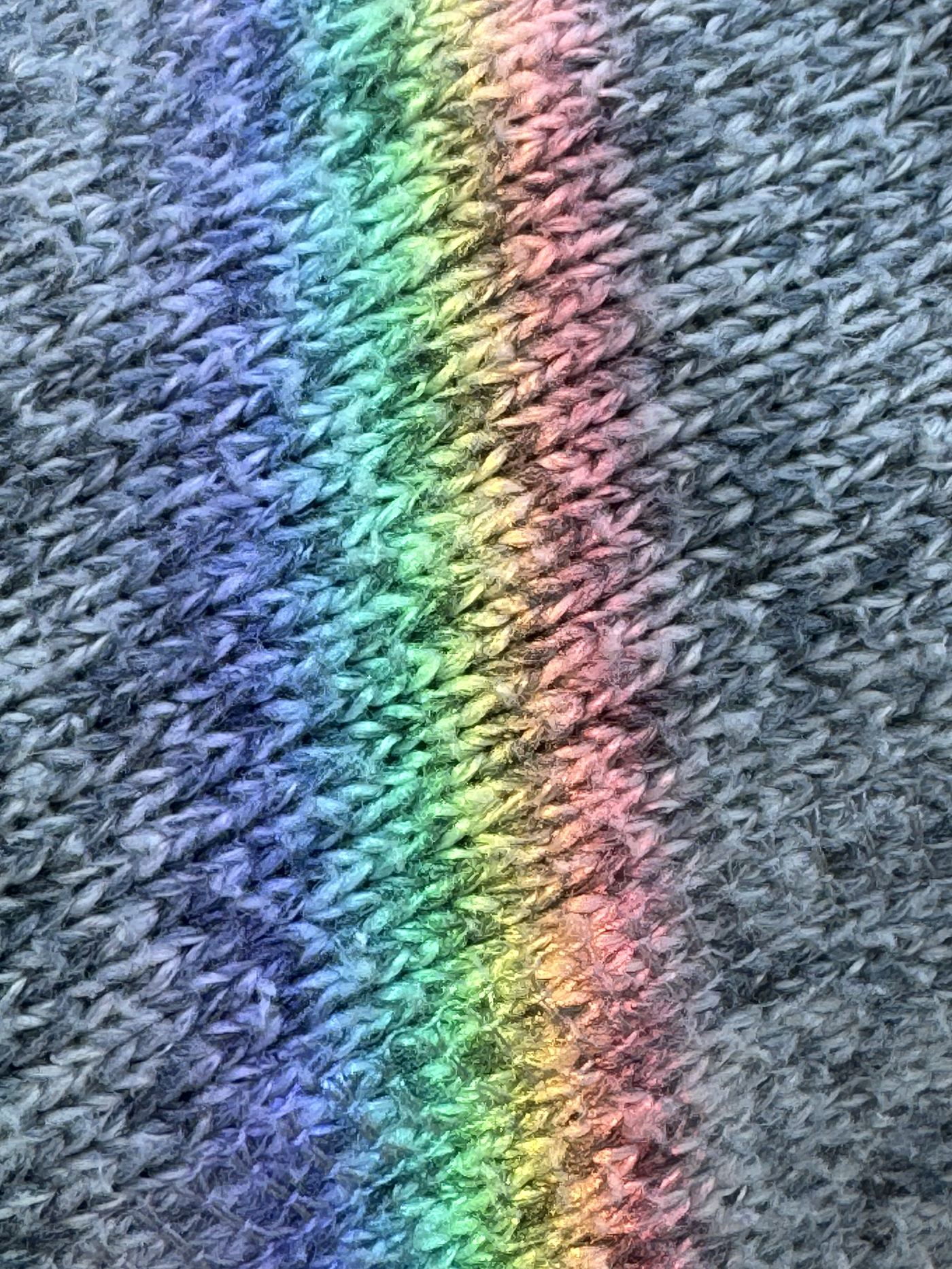 A rainbow of light cast across a knit sweater